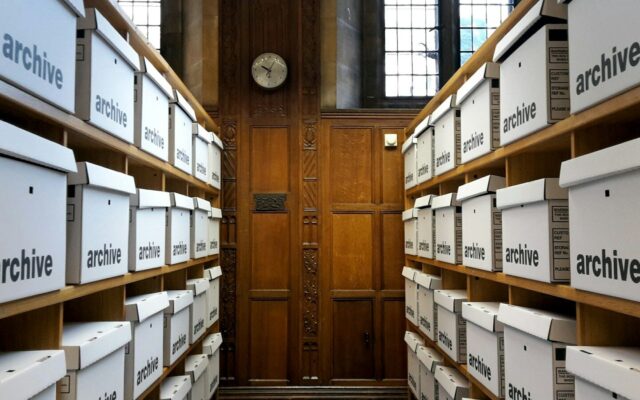 Cajas de archivo blancas ordenadas en las estanterías de una sala de archivo